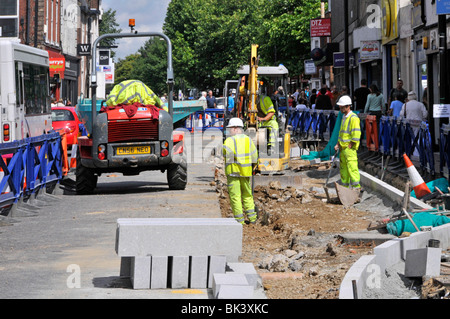 Brentwood Essex Shopping High Street Road travaille à améliorer les routes et les trottoirs ouvriers en casques de sécurité et vestes haute visibilité travaillant autour de shoppers UK Banque D'Images