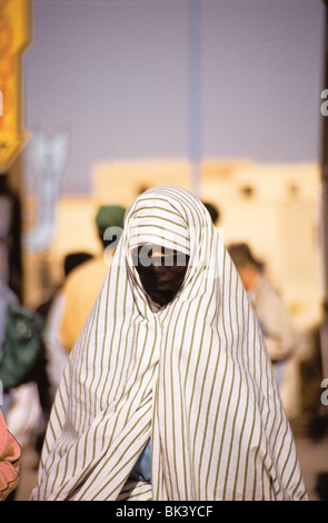 Portrait d'une femme marocaine portant une couverture traditionnelle noire et des vêtements rayés à Meknes, au Maroc Banque D'Images