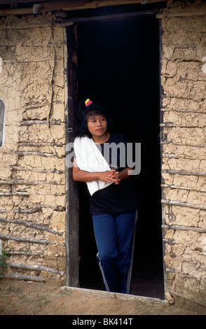 Jeune femme aux portes d'un bâtiment d'adobe, Venezuela Banque D'Images