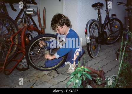 La fixation d'une roue de vélo garçon à Hagoshrim Kibbutz, Israël Banque D'Images