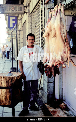 Portrait d'un boucher avec carcasse de chèvre en dehors d'une boucherie à Amman, Jordanie Banque D'Images