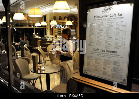 Un membre du personnel en regardant par la fenêtre de Bettys Cafe et salons de thé dans la région de Harrogate Yorkshire UK Banque D'Images