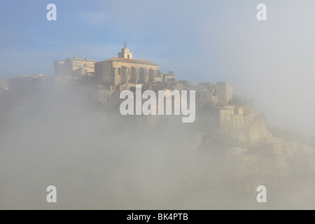 Le pittoresque village médiéval perché de Gordes dans le Luberon dans un matin brumeux Banque D'Images