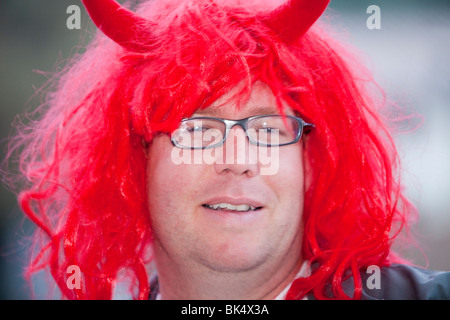 Un homme portant une perruque rouge et devil horns à Jindabyne, Australie. Banque D'Images