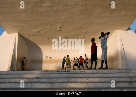 Enfants jouant au football dans une structure monumentale dans le centre ville de Port au Prince, Haïti Banque D'Images