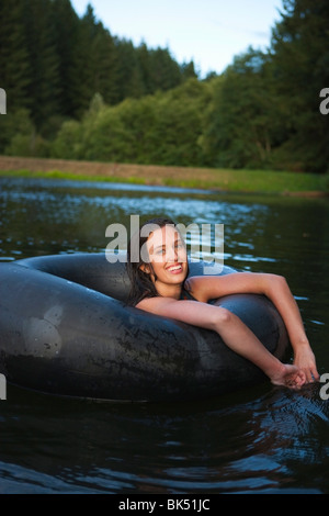 Femme flottant dans un tube intérieur, près de Portland, Oregon, USA Banque D'Images