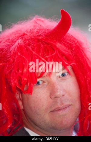 Un homme portant une perruque rouge et devil horns à Jindabyne, Australie. Banque D'Images