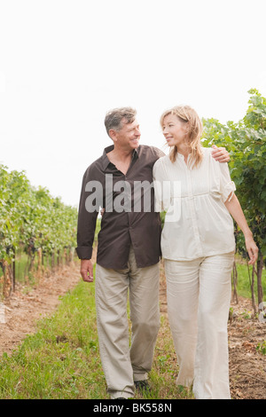 Couple Walking Through Vineyard Banque D'Images