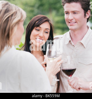 Groupe de personnes à l'extérieur de boire du vin Banque D'Images