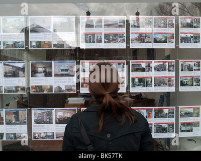 Femme à la recherche de maisons à vendre à des agents immobiliers fenêtre dans Utrecht Pays-Bas Banque D'Images