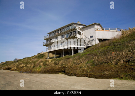 Une maison de plage est située sur les dunes de sable érodé par les vagues de l'océan Pacifique et de l'eau élevé à Newport, Oregon Banque D'Images