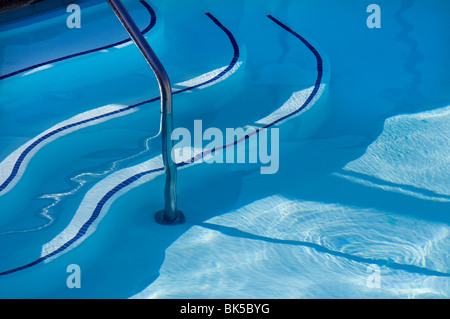 Panneaux d'escalier et rampe de sécurité dans l'eau bleue de la piscine Banque D'Images