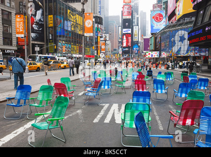 Chaises de jardin dans la route pour le public de s'asseoir dans la zone piétonne de Times Square, NYC Banque D'Images