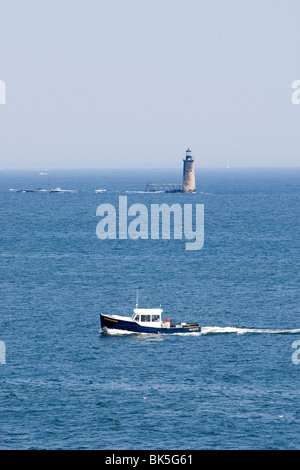 Un bateau de pêche et un phare au large de la côte de Cape Elizabeth Maine Banque D'Images
