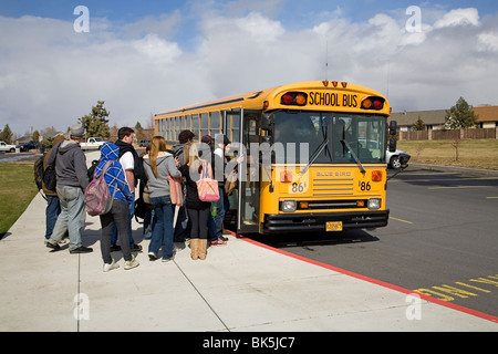 Les élèves du secondaire à bord d'un autobus scolaire pour le voyage de retour de l'école Banque D'Images