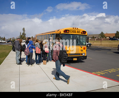 Les élèves du secondaire à bord d'un autobus scolaire pour l'après-midi, retour à la maison après l'école Banque D'Images