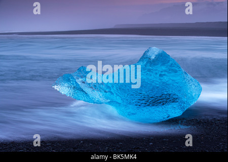 Iceberg bleu translucide échoués sur Breidamerkursandur black sands, près de Jokulsarlon glacial lagoon, est de l'Islande Banque D'Images