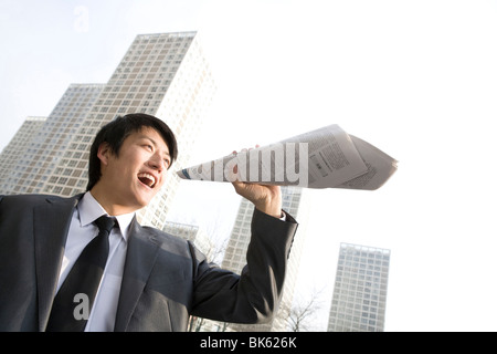 Businessman de la radiodiffusion dans l'avant du bâtiment de bureaux Banque D'Images