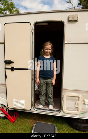 Young Girl smiling at porte de caravane de la famille. Modèle entièrement libéré Banque D'Images