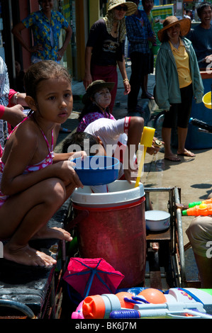 Jeune fille thaïe est assis avec un seau d'eau à Songkran festival à Koh Phangan, Thaïlande Banque D'Images