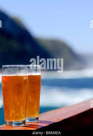 Deux verres de bière sur une balustrade, avec un littoral spectaculaire comme arrière-plan. Se concentrer sur des verres Banque D'Images