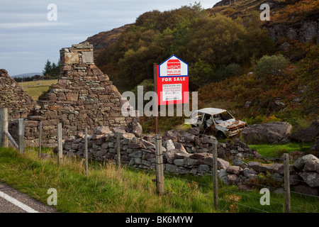 Tableau de vente en ruine. Maison en bord de route abandonnée, une maison en pierre en ruines à Ullapool pour la vente et la restauration, Écosse, Royaume-Uni Banque D'Images