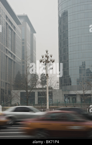 Grand boulevard avec lampe rue détail et floue voiture à fort trafic sur un jour brumeux à Beijing Chine associant la pollution. Banque D'Images