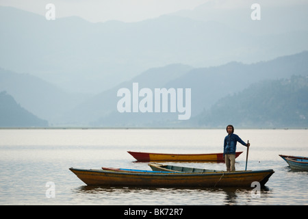 Un homme se tient dans un canot sur le lac Pewha à Pokhara (Népal) le lundi 26 octobre 2009. Banque D'Images