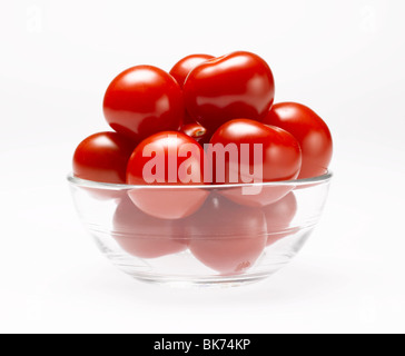 Tomates cerise dans bol en verre sur fond blanc Banque D'Images