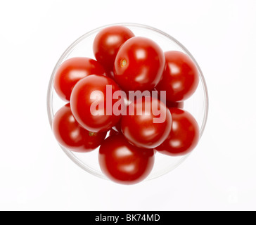 Tomates cerise dans bol en verre sur fond blanc Banque D'Images