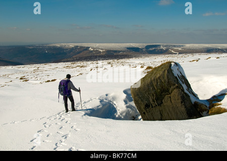 Un marcheur admire la vue vers la colline de Bleaklow Noir, Peak District, Derbyshire, Angleterre, RU Banque D'Images