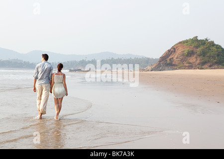 Couple en train de marcher dans la mer Banque D'Images