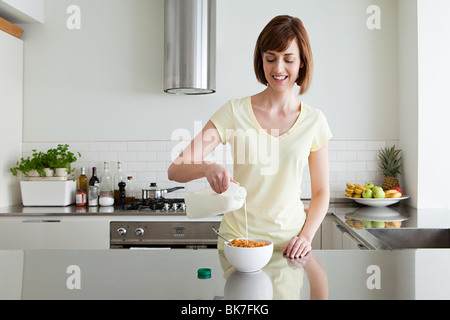 Woman pouring céréales lait sur Banque D'Images