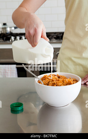Woman pouring céréales lait sur Banque D'Images