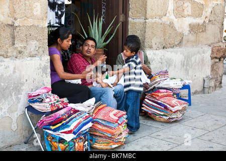 Heureux les jeunes de la famille mexicaine avec bébé et petit garçon textile vente sur le trottoir de la rue Macedonio Alcala dans la ville d'Oaxaca Banque D'Images