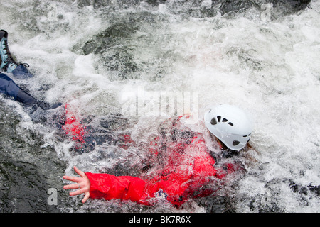 Les membres de l'/Langdale Ambleside Mountain Rescue Team train dans les techniques de sauvetage en eaux vives sur la rivière Brathay Banque D'Images