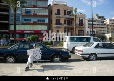 Un résident de Beyrouth de lire les dernières nouvelles sur la corniche de Beyrouth, Liban Banque D'Images