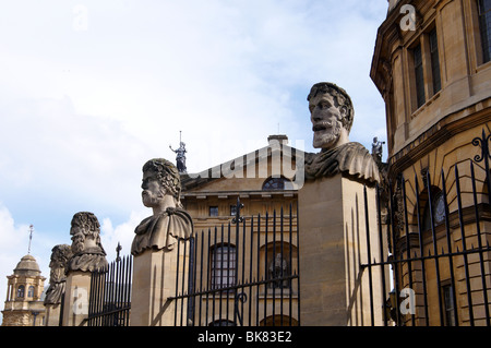 Les têtes de pierre au-dessus du garde-corps entourant l'avant du Sheldonian Theatre, Oxford, Angleterre Banque D'Images