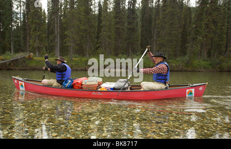 Deux hommes en canoë, kayak, canoë, claire, l'eau peu profonde d'Upper Liard River (Territoire du Yukon, Canada Banque D'Images