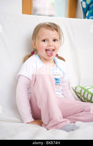 Girl sitting on a sofa Banque D'Images