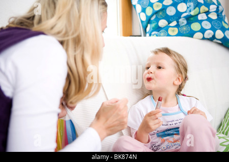 Fille avec mère appliquant le maquillage Banque D'Images