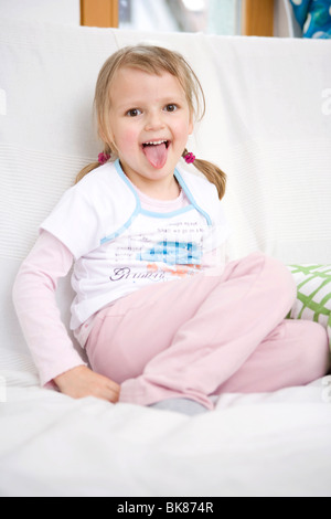 Girl sitting on a sofa Banque D'Images