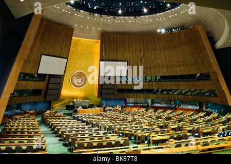 Intérieur de la salle de l'Assemblée générale des Nations Unies New York // NEW YORK, New York — intérieur de la salle de l'Assemblée générale des Nations Unies au siège des Nations Unies à New York. La salle comprend des rangées de bureaux pour les états membres, chacun équipé d'un microphone, face à un podium central orné de l'emblème des Nations Unies. La conception met l'accent sur la nature globale de l'organisation. Banque D'Images