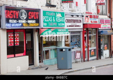 Une rangée de boutiques d'aliments à emporter dans la région de Blackburn, Lancashire, Royaume-Uni. Banque D'Images