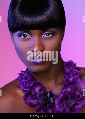Belle jeune femme noire très gros plan avec le maquillage et l'arrière-plan en violet les couleurs. Portrait de beauté. Banque D'Images