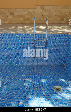 Sol carrelé bleu piscine vide sur une journée ensoleillée sans eau Banque D'Images