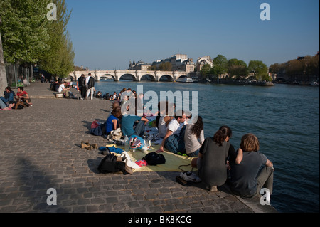 Paris, France, la foule profite du temps printanier sur le quai de la Seine, groupe d'amis jeunes adultes en vacances, assis dehors, quai, ville [arrière] ensoleillé Banque D'Images