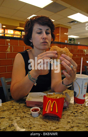 Femme mangeant à McDonalds Banque D'Images