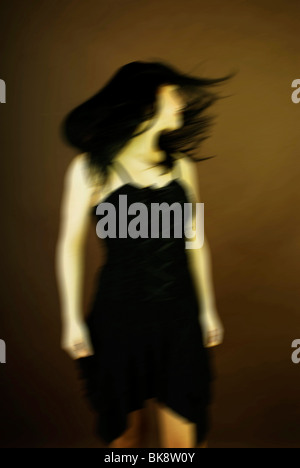 Dark-haired woman tossing ses cheveux, mouvement Banque D'Images