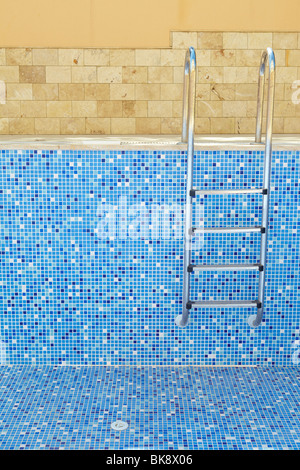Sol carrelé bleu piscine vide sur une journée ensoleillée sans eau Banque D'Images